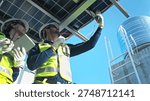 Engineering team measuring solar panel system performance and recording data using digital devices on a modern rooftop facility