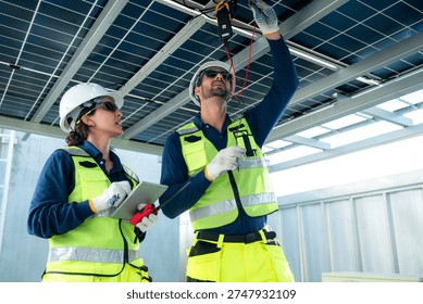 Engineering team measuring solar panel system performance and recording data using digital devices on a modern rooftop facility