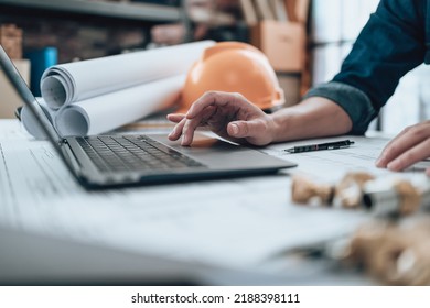 Engineering working with drawings inspection on laptop  in the office and Calculator, triangle ruler, safety glasses, compass on Blueprint. Engineer, Architect, Industry and factory concept. - Shutterstock ID 2188398111