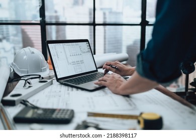 Engineering working with drawings inspection on laptop  in the office and Calculator, triangle ruler, safety glasses, compass on Blueprint. Engineer, Architect, Industry and factory concept. - Shutterstock ID 2188398117