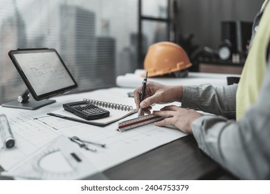 Engineering working with drawings inspection and writing on the office desk and Calculator, triangle ruler, safety glasses, compass, vernier caliper on Blueprint.  - Powered by Shutterstock