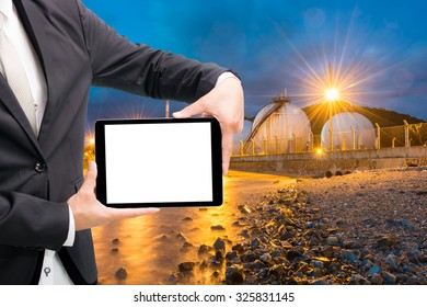 Engineering working hold tablet in front of oil refinery power station