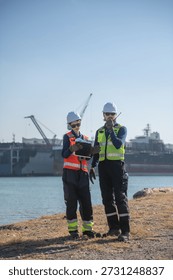 Engineering working at shipyard, Professional logistics monitoring cargo operations at industrial shipyard, transportation, harbor, infrastructure, distribution, freight, commercial shipping.