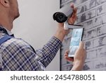 Engineers adjusting security surveillance system with CCTV technician