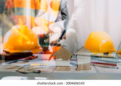 Engineers or architects is watching on model building and blueprint in working site.Construction and structure concept.