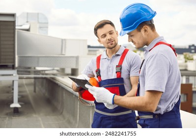 Engineers or builders standing on the roof, reviewing blueprints and plan a construction site. Communication and preparation, well-coordinated building project, planning stages of construction. - Powered by Shutterstock