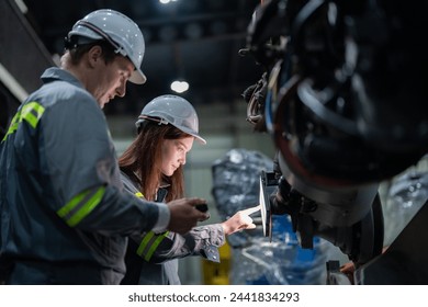 engineers check control heavy machine robot arm. Diverse Team of Industrial Robotics Engineers Gathered Around Machine. Professional Machinery Operators repair electric robot on bright digital panel. - Powered by Shutterstock