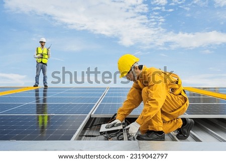 Engineers check the installation of solar panels on the factory roof, command engineers, supervise the installation of solar panels, engineers and technicians check the operation of solar panels.