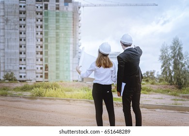 Engineers Checking Plan On Building Site.