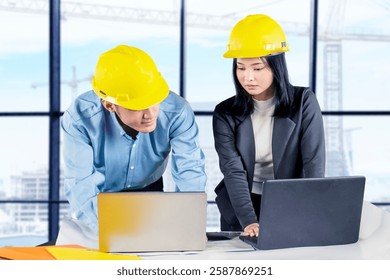 Engineers Collaborating on Construction Project with Laptops in Modern Office