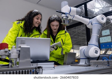 Engineers collaborating on robotics project in modern facility during daytime