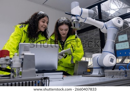 Engineers collaborating on robotics project in modern facility during daytime