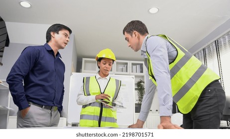 Engineers And Competent Employer Discussing Plans And Blueprints Together With Tablet In The Office. Concept Of Team Contribution Of Ideas For Engineering Project.