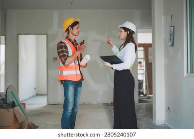Engineers and construction workers collaborating on a building site, reviewing blueprints and discussing progress for a renovation project