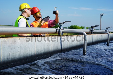                       Engineers controlling a quality of water ,aerated activated sludge tank at a waste water treatment plant        