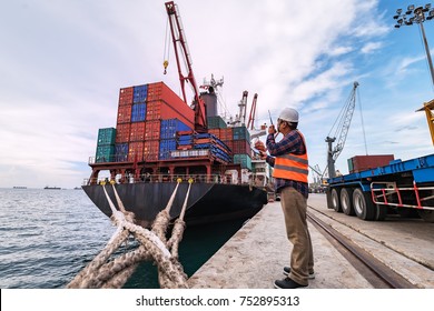 Engineers and crane.smiling dock worker holding radio and ship background - Shutterstock ID 752895313