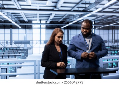 Engineers in data center tracking network traffic and activity using augmented reality, installing and configuring software updates. Coworkers performing database backups using AR holograms