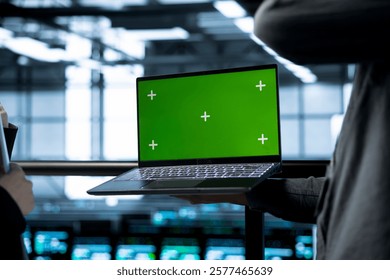 Engineers in data center using green screen laptop, implementing predictive analytics scripts, reviewing equipment health, adjusting system parameters, coordinating maintenance tasks
