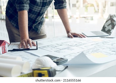 Engineers are designing working on blueprints and analyzing the structure of the project. - Shutterstock ID 2116555166