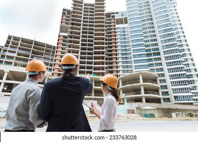 Engineers Discussing Construction Of The Building, Rear View