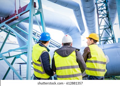 Engineers discussing maintenance of a petrochemical plant. Technical inspection. Oil and gas industry.