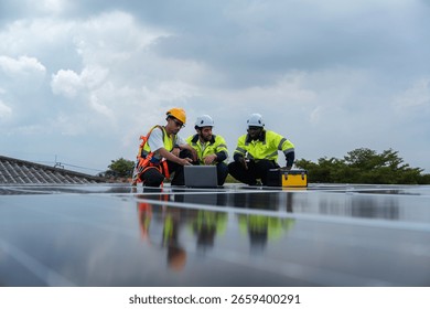 Engineers from diverse backgrounds collaborating on clean energy project, using laptop to monitor solar performance, reflecting unity and technological progress in green energy sector.