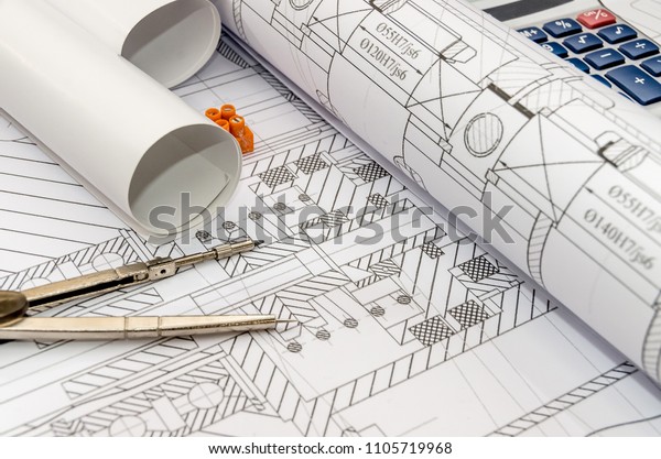 Engineers\
drawing with compass, calculator and\
rolls