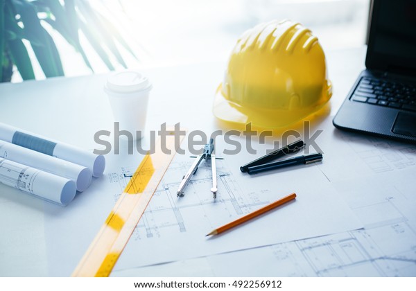 Engineers equipment and\
blueprints on table