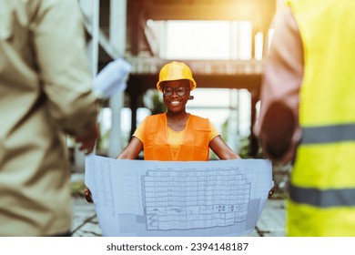 Engineers having meeting regarding new construction phase. Engineers standing outdoors on construction site, using blueprints. Workers talking at construction site reviewing plans  - Powered by Shutterstock