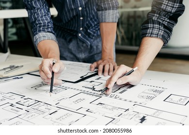 Engineers are helping to design work on blueprints and collaborate on structural analyzing of project types. - Shutterstock ID 2080055986