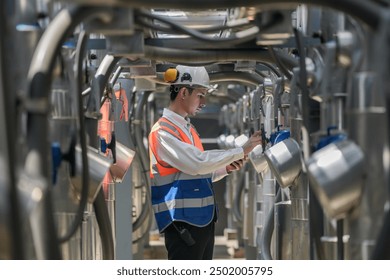 Engineers inspect gas and water pipes for power and cooling in industrial and building systems. workers in safety gear work seriously in oil and gas refining plant with pipes connecting to machinery. - Powered by Shutterstock