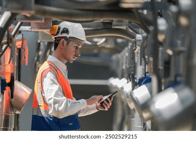 Engineers inspect gas and water pipes for power and cooling in industrial and building systems. workers in safety gear work seriously in oil and gas refining plant with pipes connecting to machinery. - Powered by Shutterstock