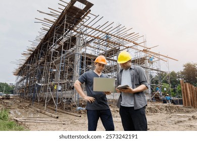 Engineers inspecting construction progress at a building site using digital devices. Collaboration and technology driving modern infrastructure development.