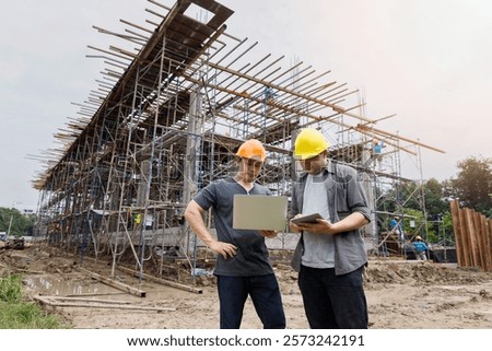 Engineers inspecting construction progress at a building site using digital devices. Collaboration and technology driving modern infrastructure development.