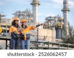 Engineers Inspecting Operations at a Water Pumping Station with Large Pipes and Industrial Towers