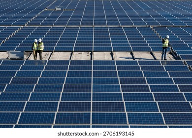Engineers installing, checking, and maintaining a large solar panel array on a rooftop. Generating clean, sustainable electricity