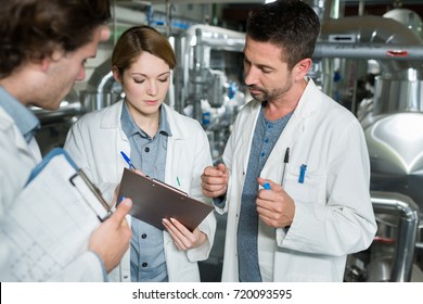 engineers in lab coats working in a factory