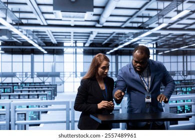 Engineers looking at AR visualization, doing disaster recovery planning in data center. Coworkers using augmented reality in server room to reduce downtime, ensuring business continuity