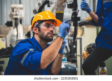 Engineers mechanic using computer controller Robotic arm for welding steel in steel factory workshop. Industry robot programming software for automated manufacturing technology - Powered by Shutterstock