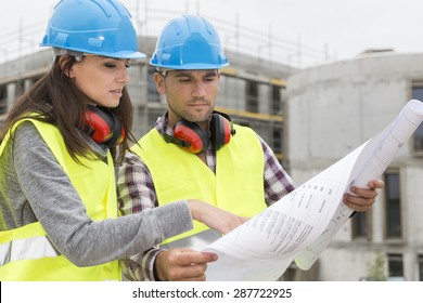 Engineers on building site checking plans