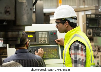 Engineers operating a machine in factory