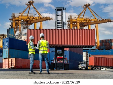 Engineers are overseeing the transportation of cargo with containers inside the warehouse. Container in export and import business and logistics. - Shutterstock ID 2022709529