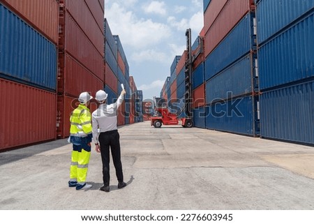 Engineers are overseeing the transportation of cargo with containers inside the warehouse. Container in export and import business and logistics.