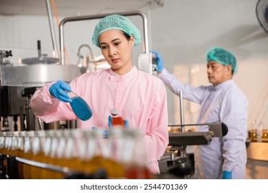 Engineers in QC roles inspect fruit juice drink production in glass bottles at the factory. Their careful examination ensures the highest quality and cleanliness in manufacturing. - Powered by Shutterstock