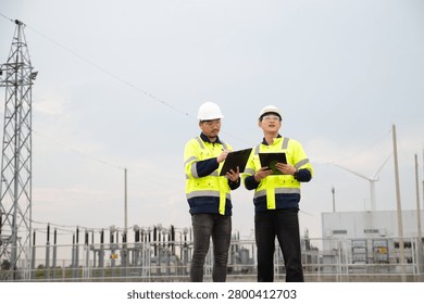 Engineers Reviewing Maintenance Data at Electrical Substation and Utility Network Site
