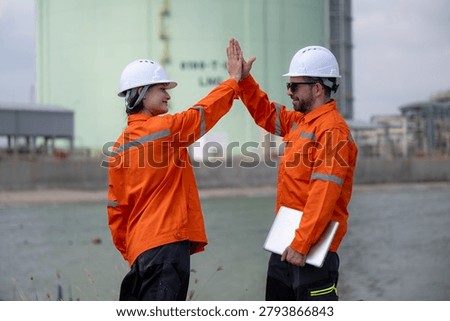Engineers successfully concluding a project with a high five at an industrial facility