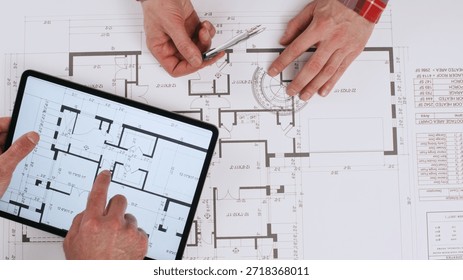 Engineers take measurements and notes while working on a paper drawing of the house, while the builder uses an electronic version of the drawing on a tablet.