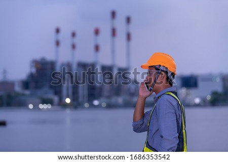 Engineers are talking on the phone to plan the work of the industrial power plant.