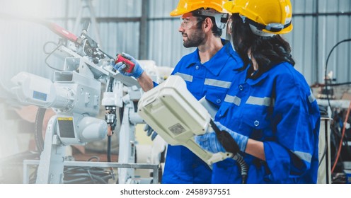 Engineers team mechanic using computer controller Robotic arm for welding steel in steel factory workshop. Industry robot programming software for automated manufacturing technology - Powered by Shutterstock