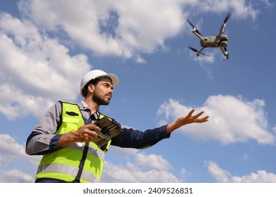 An engineers or technician are launching drones to inspect the power station for a planned work by generating electricity from a high-voltage transmission tower.